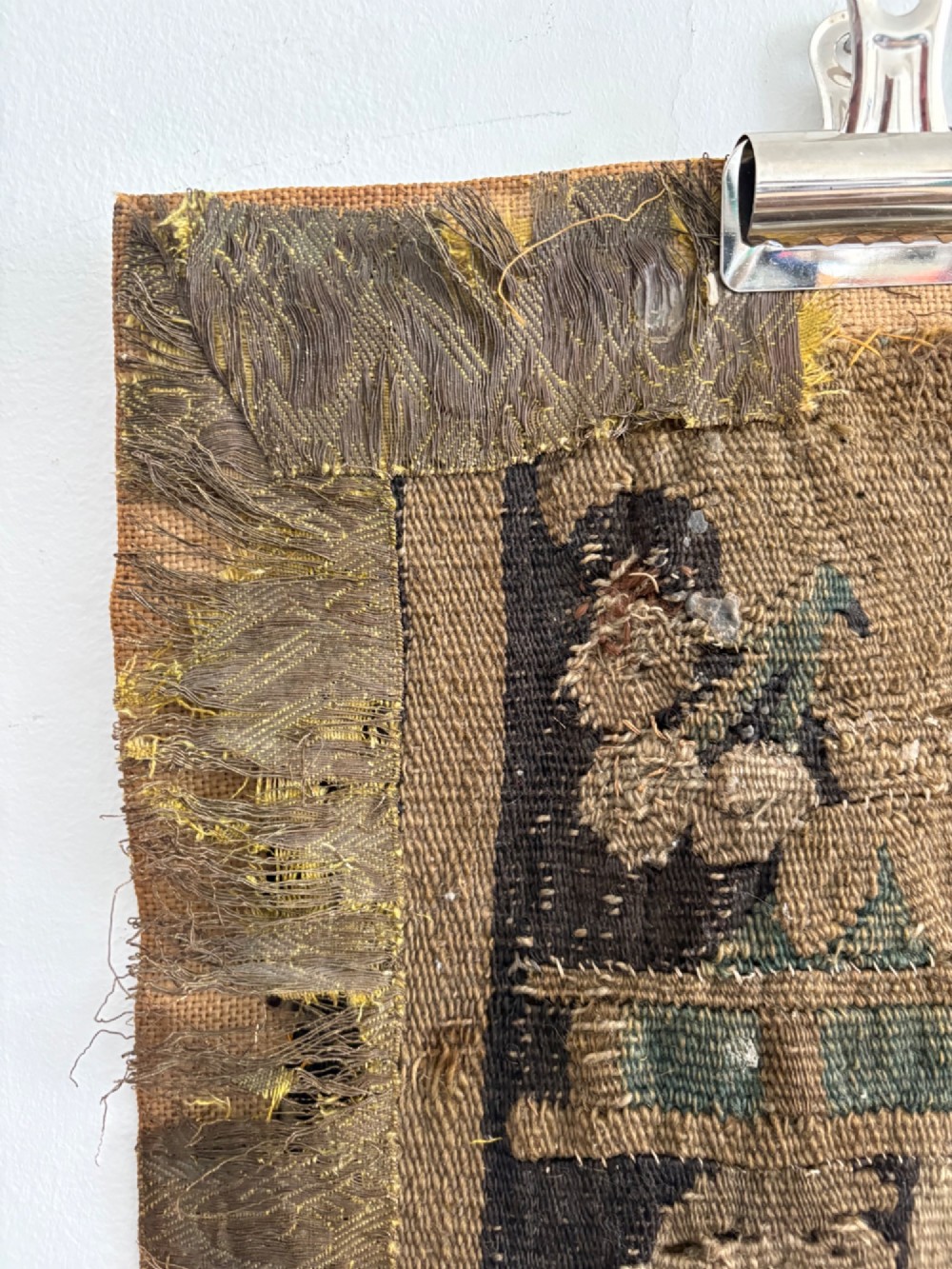 A vertical fragment of an antique hand-woven verdure tapestry featuring acanthus leaf motifs, mounted onto a natural linen backing. View VI
