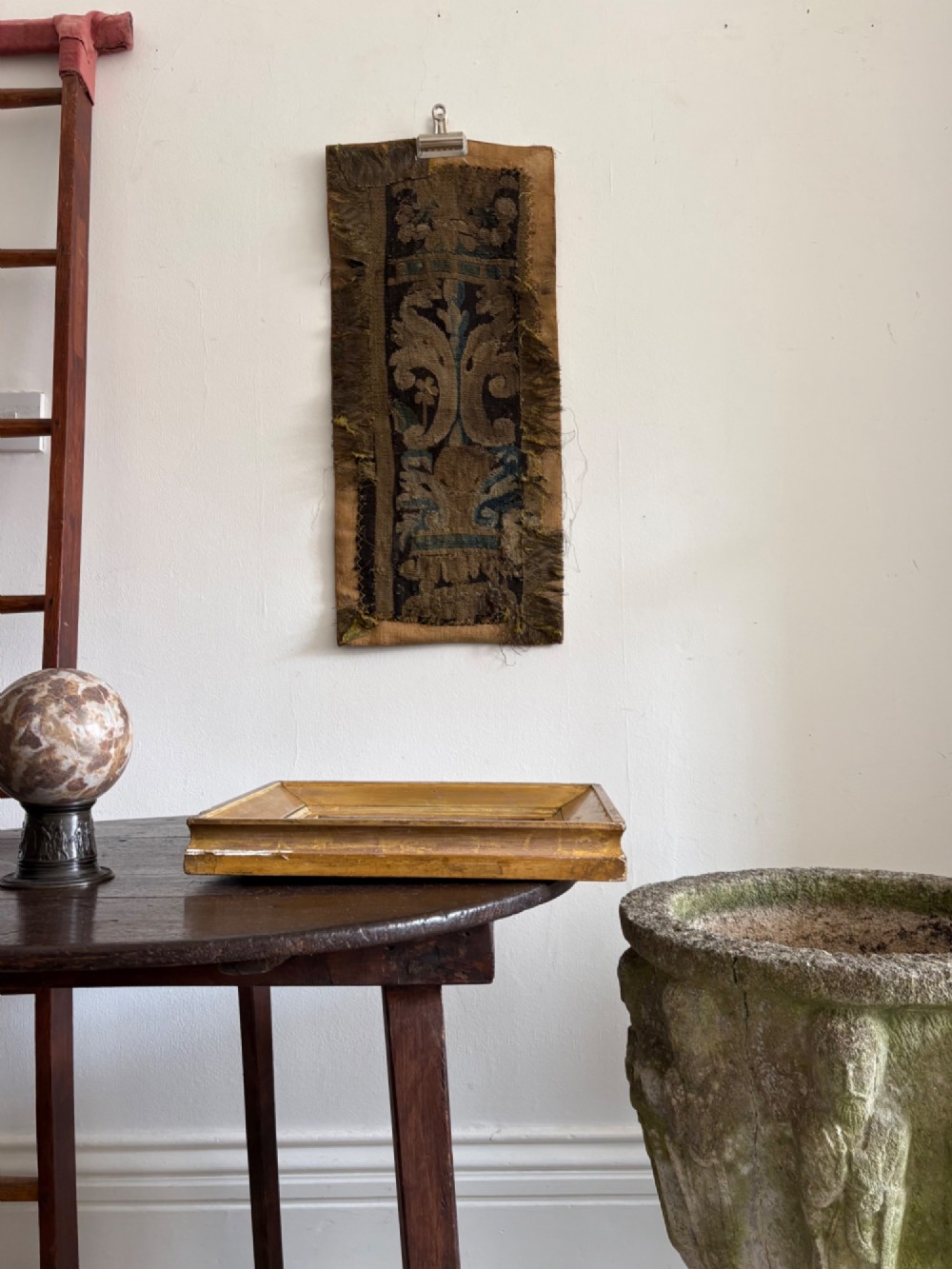 A vertical fragment of an antique hand-woven verdure tapestry featuring acanthus leaf motifs, mounted onto a natural linen backing. View VII