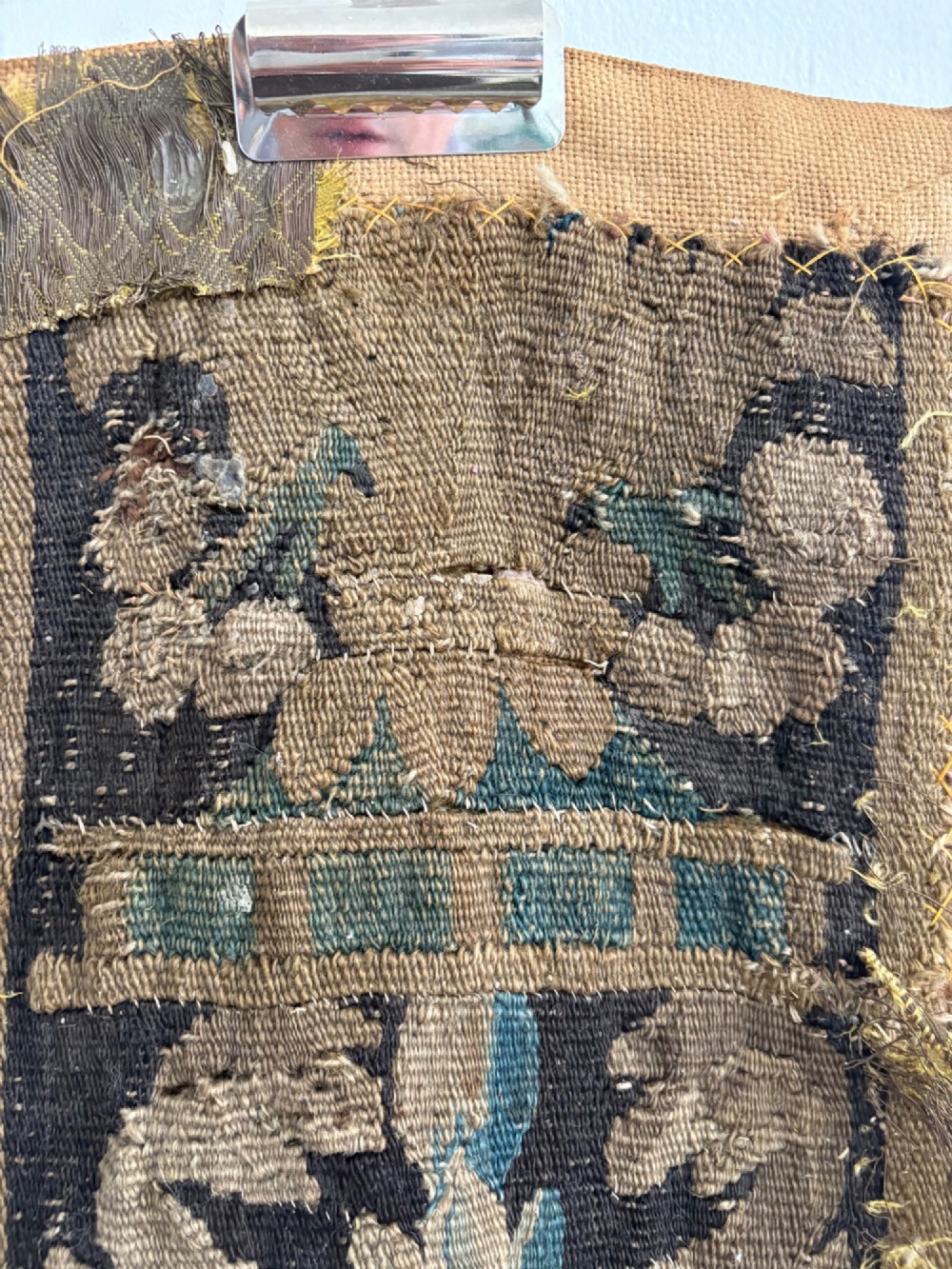 A vertical fragment of an antique hand-woven verdure tapestry featuring acanthus leaf motifs, mounted onto a natural linen backing. View VIII