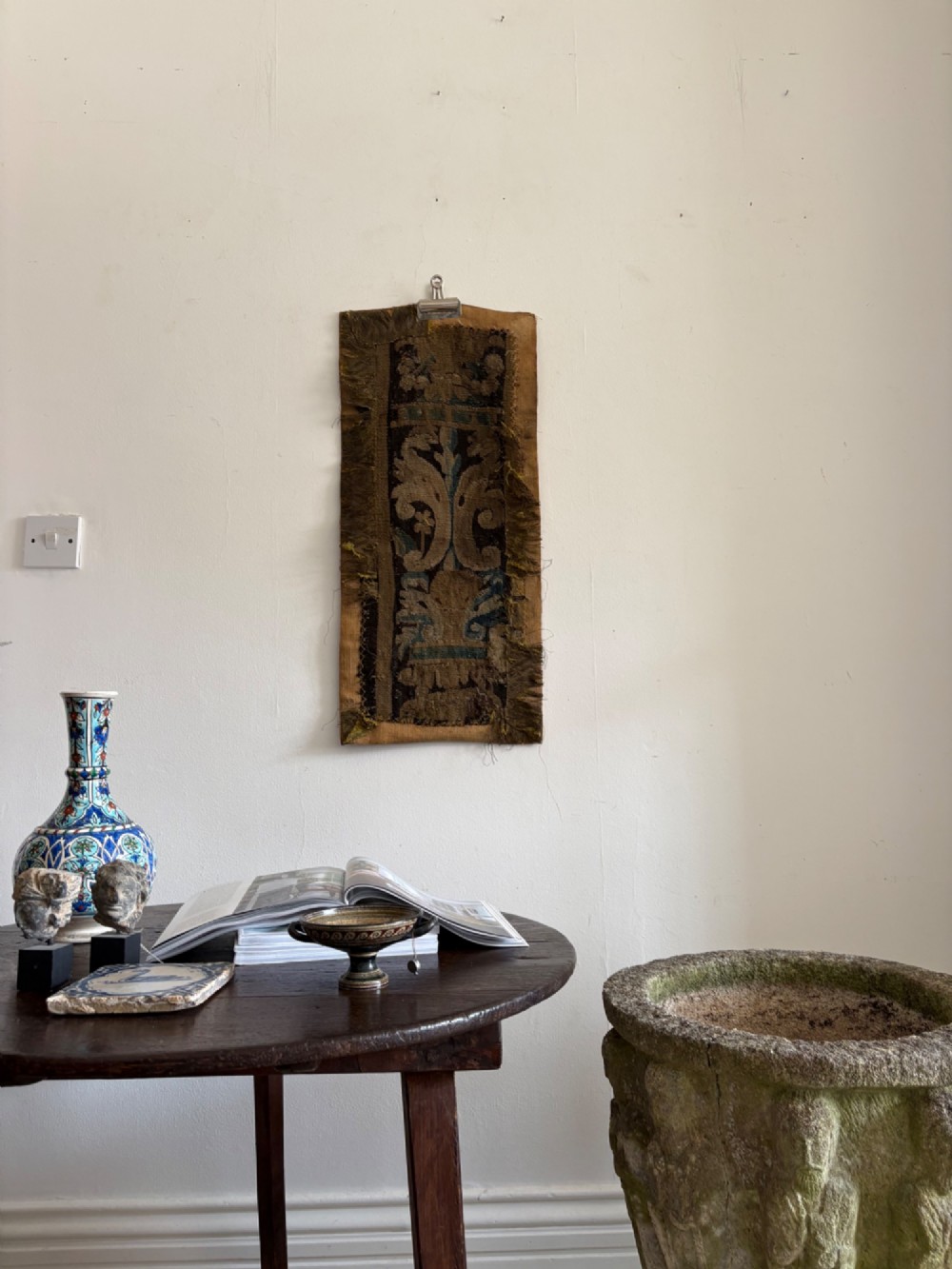 A vertical fragment of an antique hand-woven verdure tapestry featuring acanthus leaf motifs, mounted onto a natural linen backing. View XI