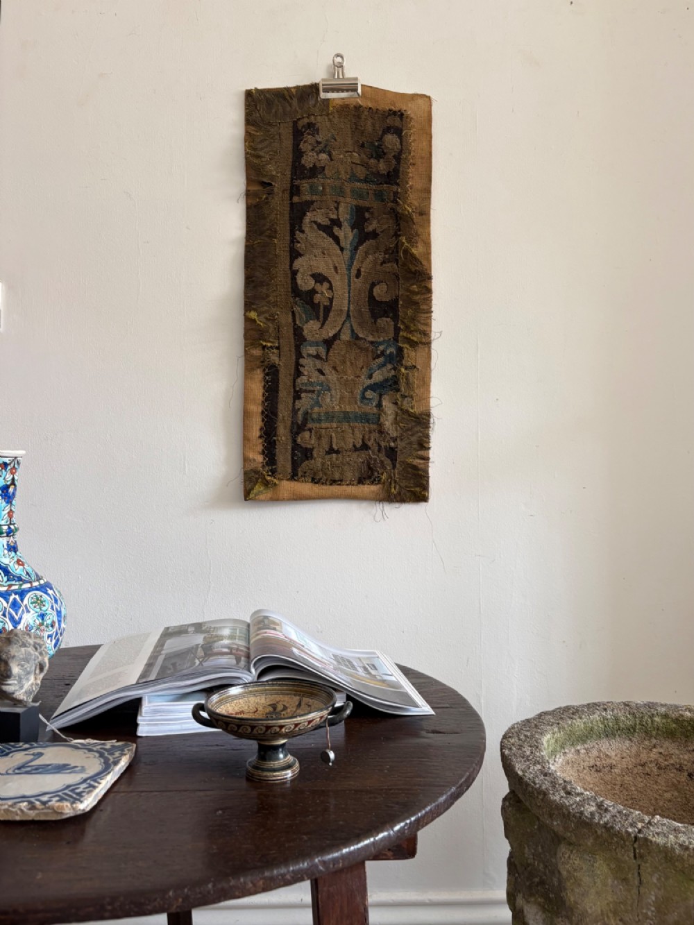A vertical fragment of an antique hand-woven verdure tapestry featuring acanthus leaf motifs, mounted onto a natural linen backing. View XII