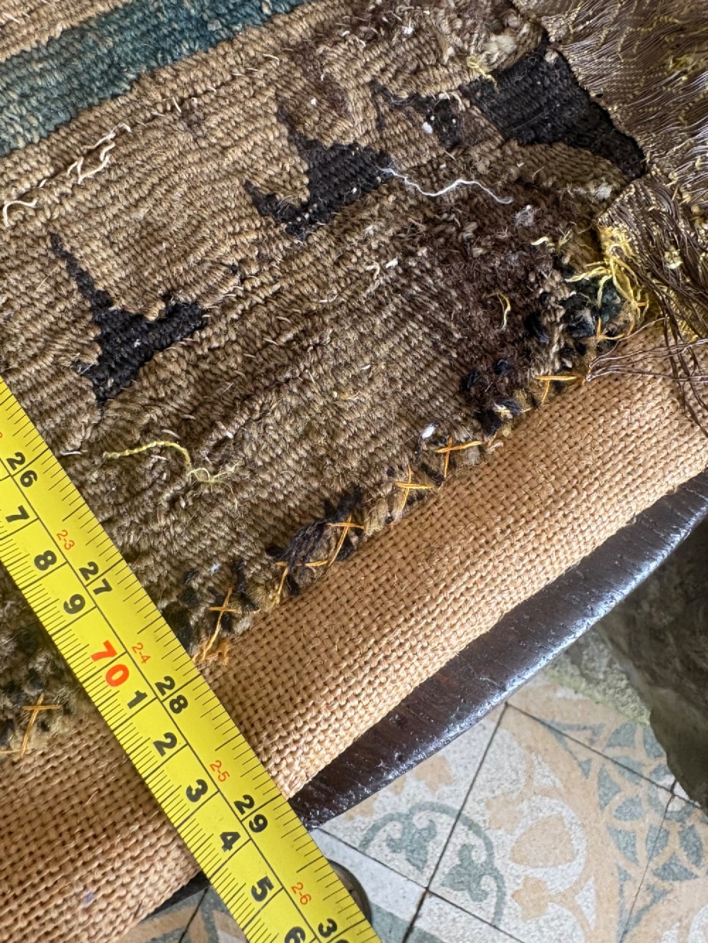 A vertical fragment of an antique hand-woven verdure tapestry featuring acanthus leaf motifs, mounted onto a natural linen backing. View XIV
