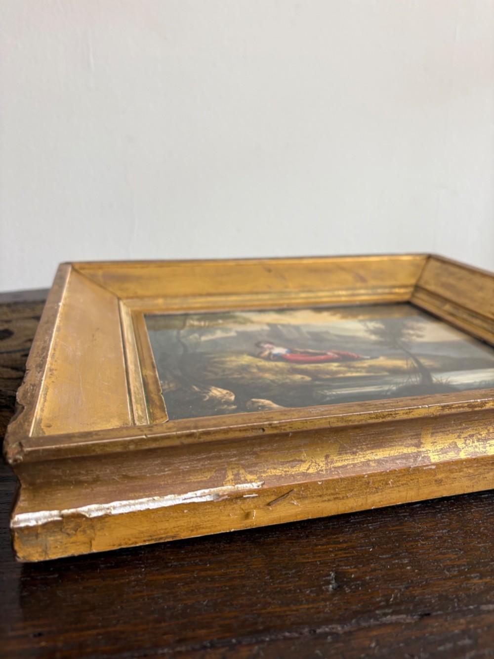 A 19th-century watercolour painting depicting a reclining figure in a landscape with ruins, set inside a broad giltwood frame. View V