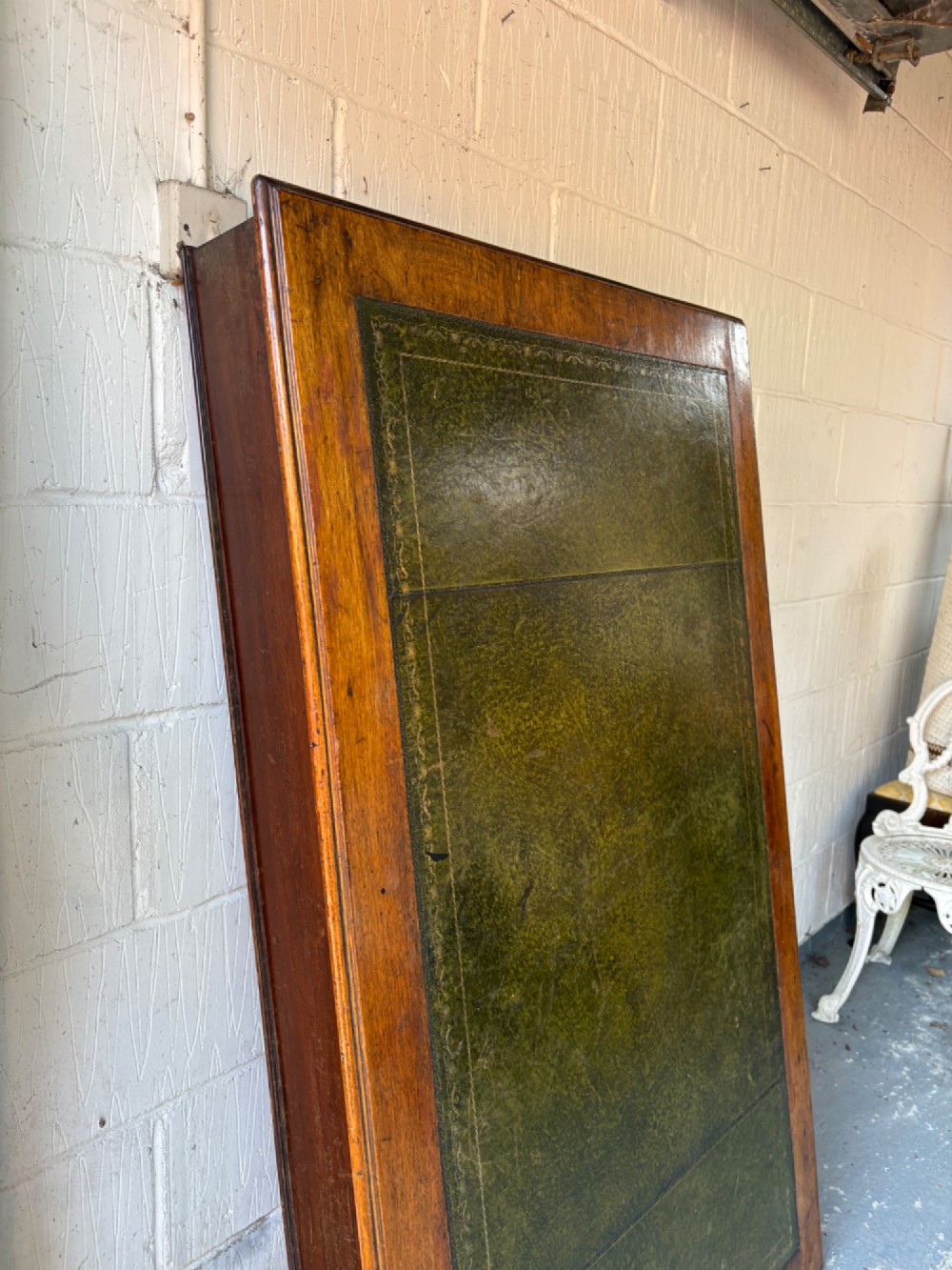 An antique dark mahogany pedestal desk featuring a green leather inset writing top, nine drawers with brass swan-neck handles, and twin pedestals on plinth bases. View III