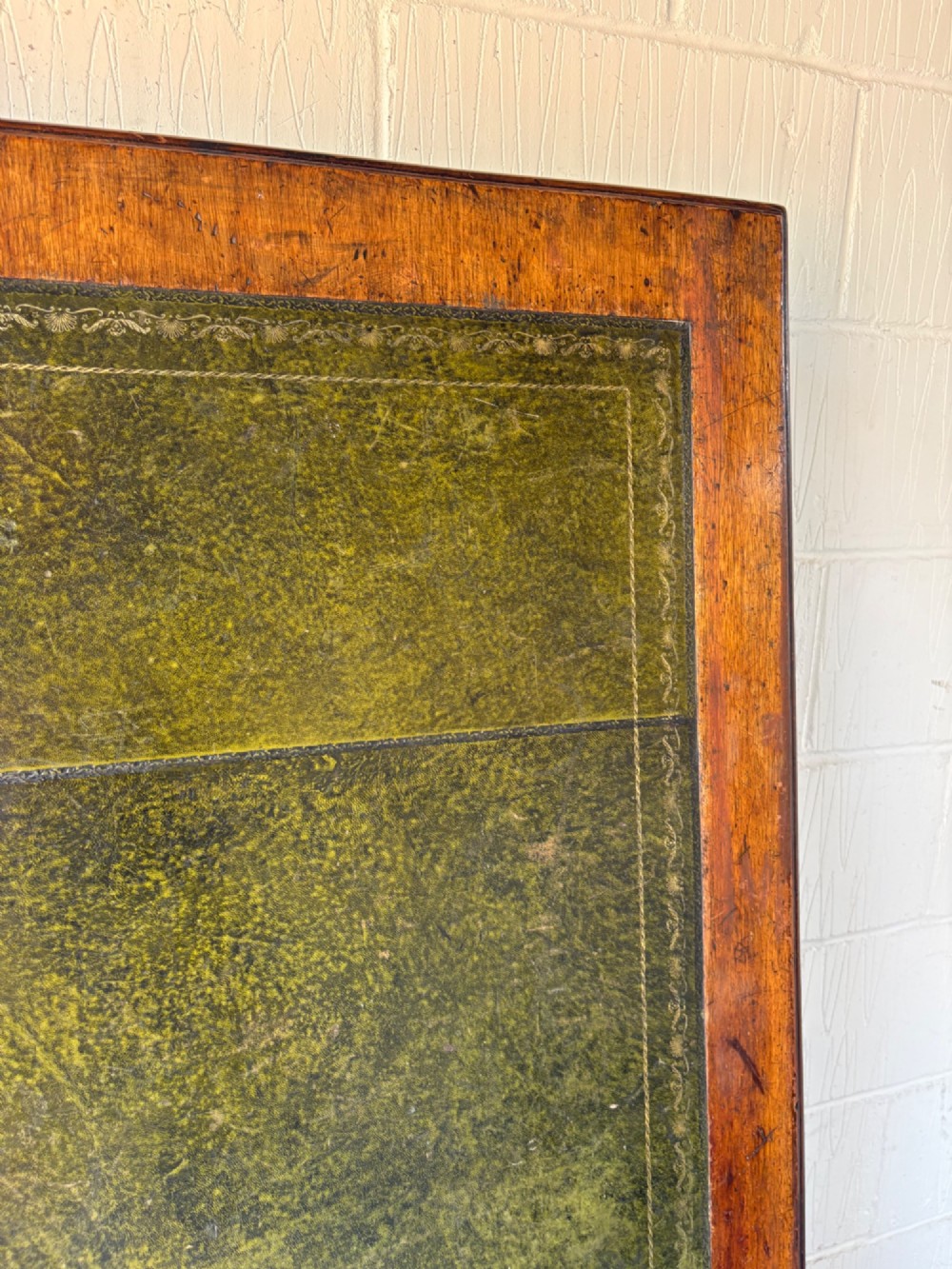 An antique dark mahogany pedestal desk featuring a green leather inset writing top, nine drawers with brass swan-neck handles, and twin pedestals on plinth bases. View XIII