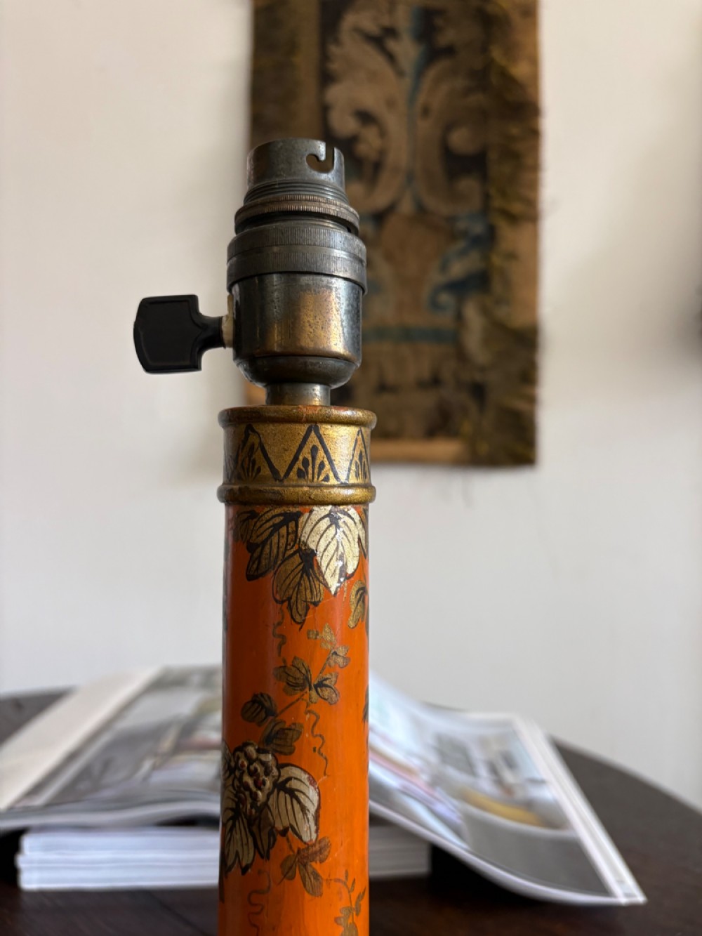 A mandarin orange lacquered table lamp base decorated with gold hand-painted floral motifs and fitted with a brass bulb holder. View II
