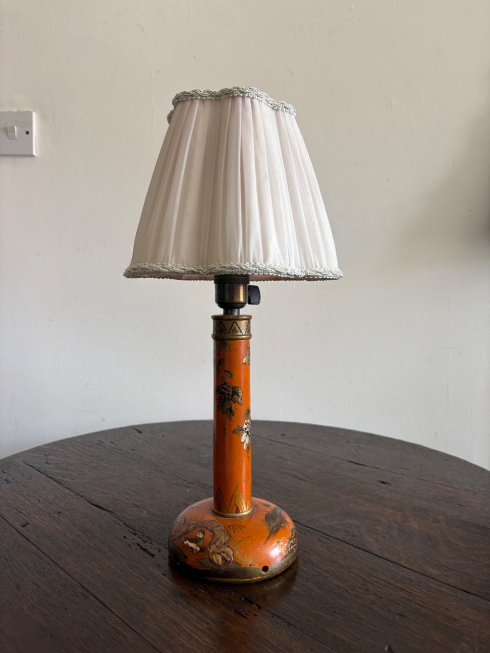 A mandarin orange lacquered table lamp base decorated with gold hand-painted floral motifs and fitted with a brass bulb holder. View XII