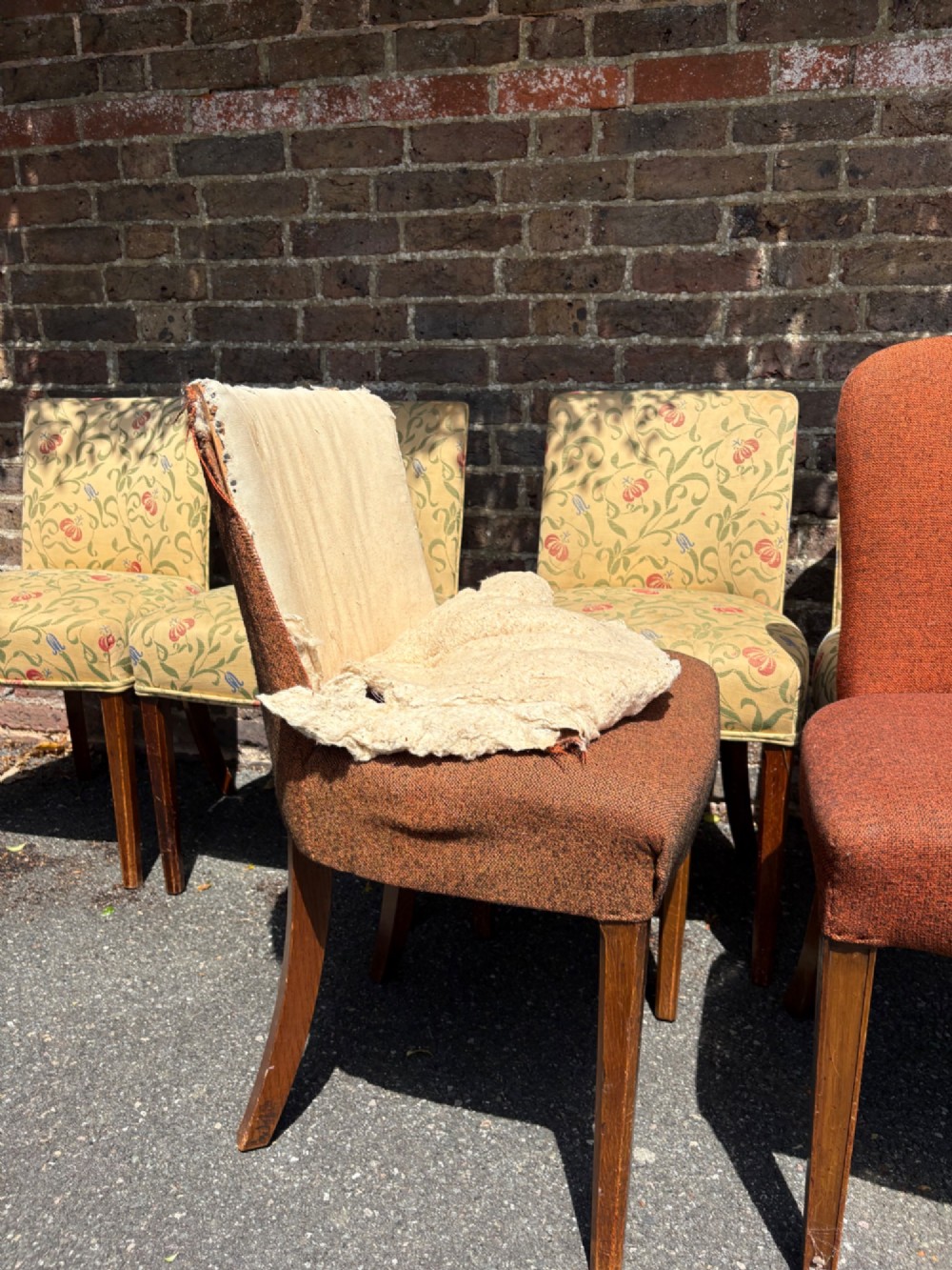 A row of 1930s Art Deco dining chairs featuring yellow floral pattern upholstery and dark oak tapered legs. View IX