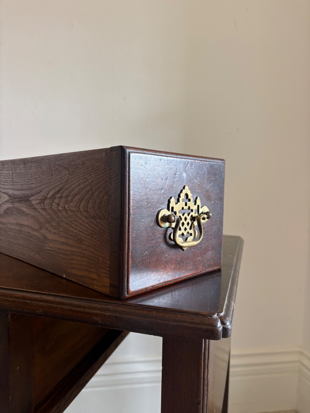 A George III style mahogany lowboy table featuring three drawers with decorative brass handles and an arched apron. View VII