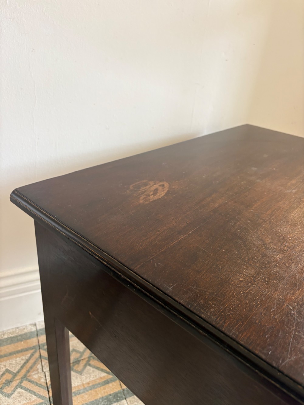 A George III style mahogany lowboy table featuring three drawers with decorative brass handles and an arched apron. View VIII