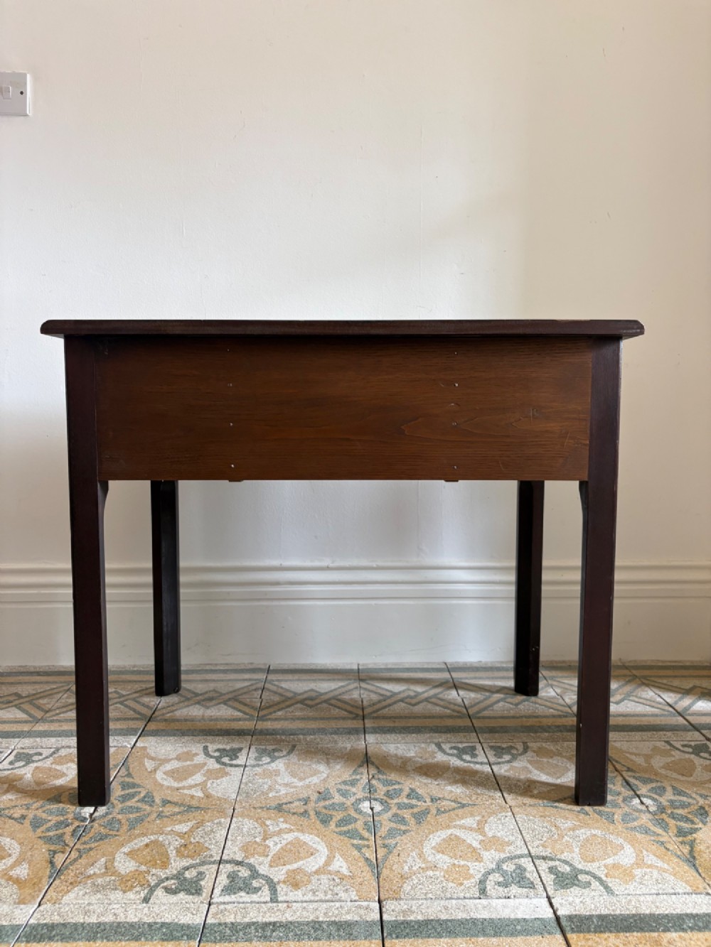 A George III style mahogany lowboy table featuring three drawers with decorative brass handles and an arched apron. View X