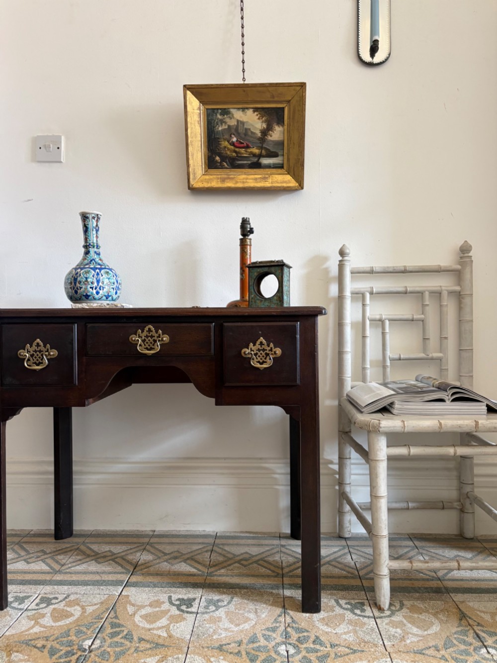A George III style mahogany lowboy table featuring three drawers with decorative brass handles and an arched apron. View XI
