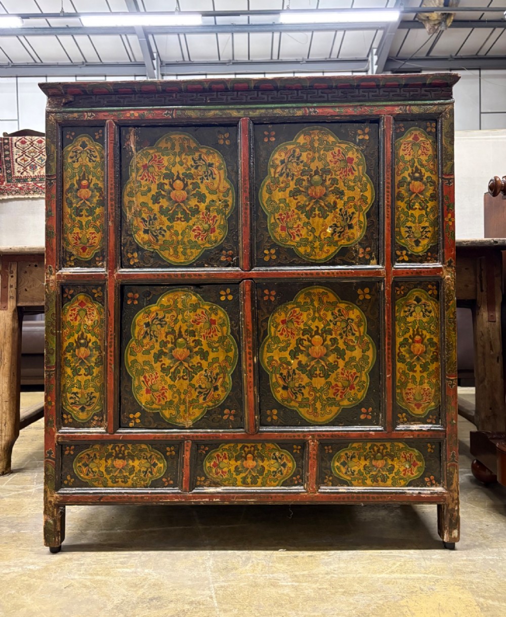 A 19th-century Tibetan wooden cabinet featuring four central hand-painted floral panels framed in red and gold mineral pigments. View II