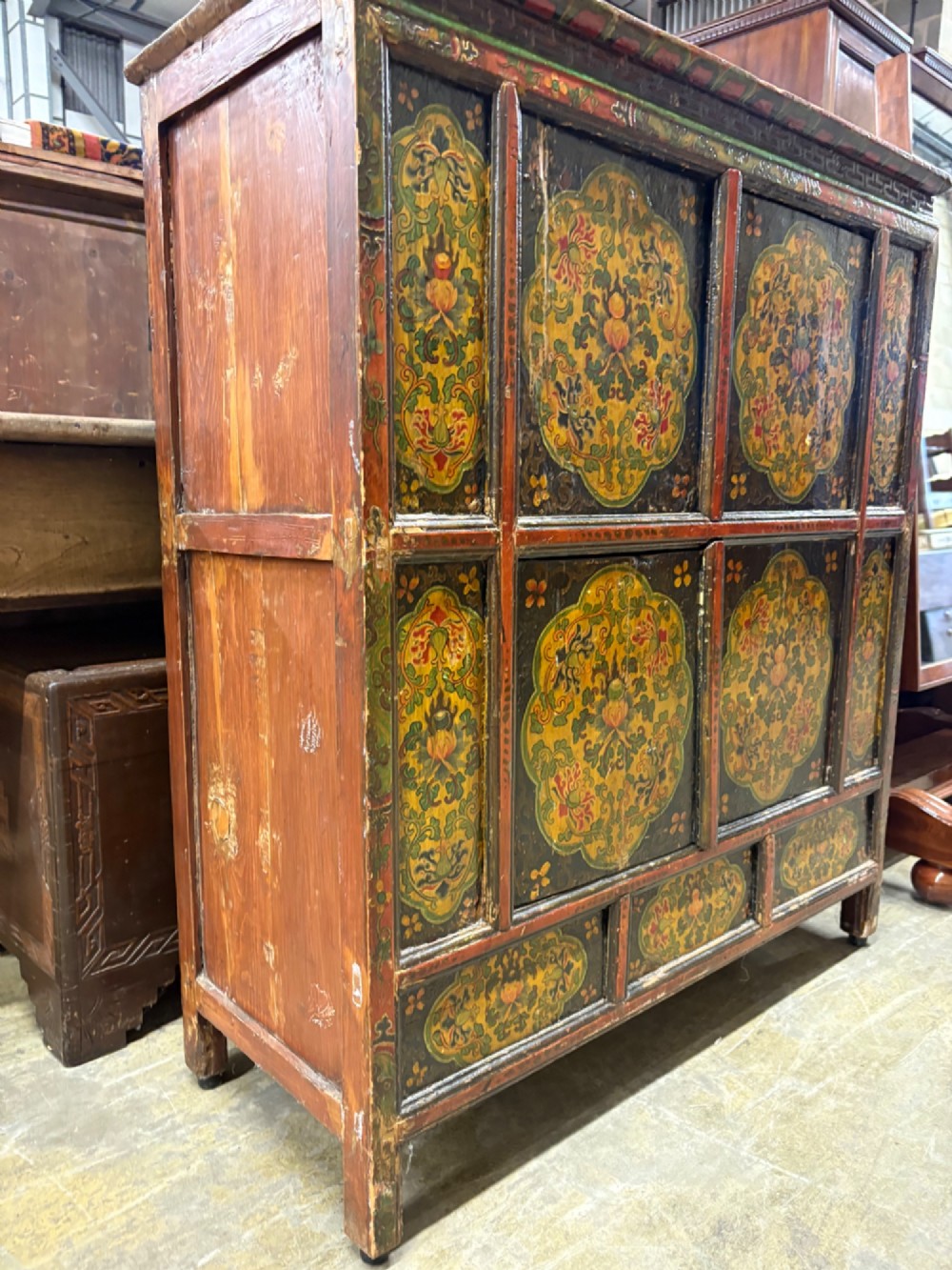 A 19th-century Tibetan wooden cabinet featuring four central hand-painted floral panels framed in red and gold mineral pigments. View VIII