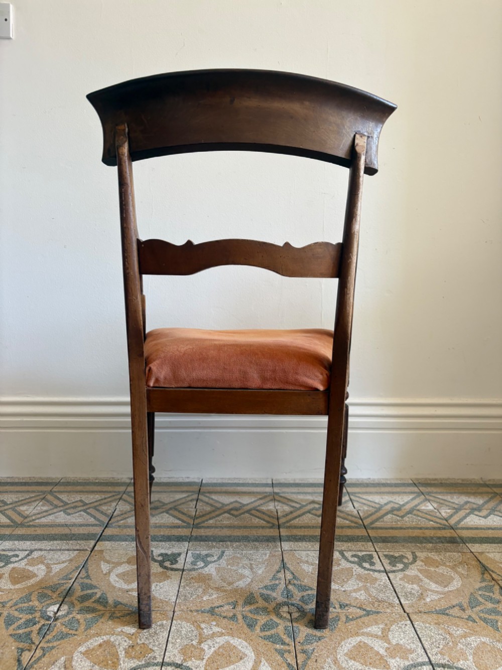 Profile view of a Late Regency mahogany open armchair with scrolled armrests, reeded front legs, and a rust orange velvet drop-in seat. View IX