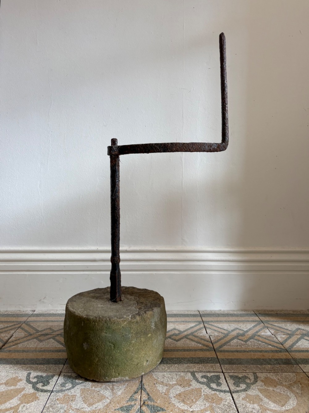 An 18th-century cylindrical carved stone weight featuring an upright hand-forged iron handle attachment. View II