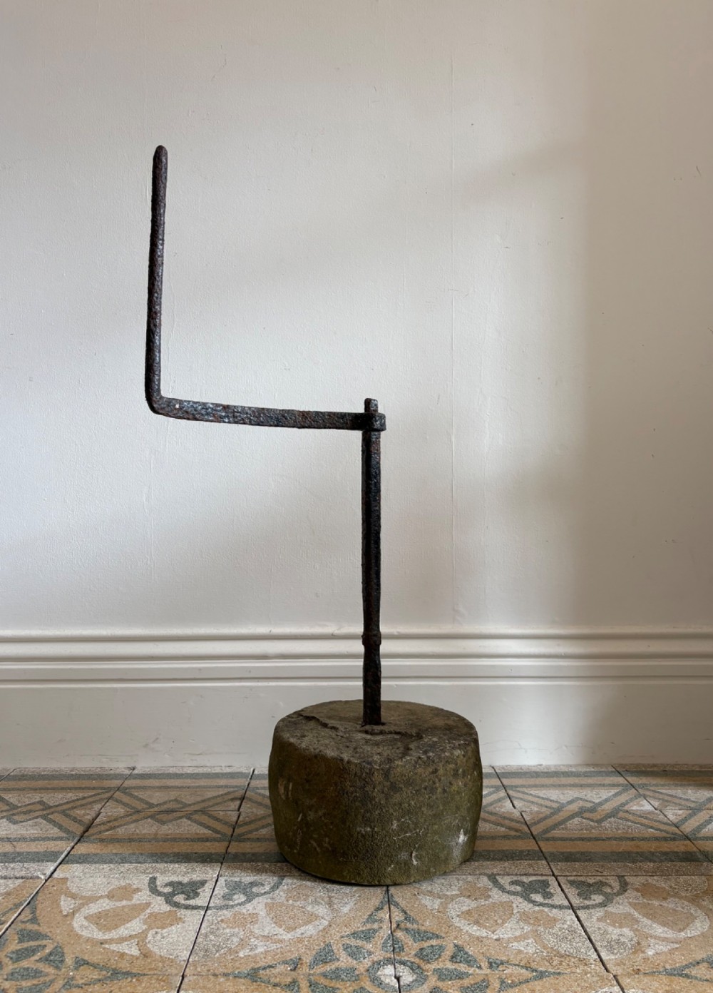 An 18th-century cylindrical carved stone weight featuring an upright hand-forged iron handle attachment. View III