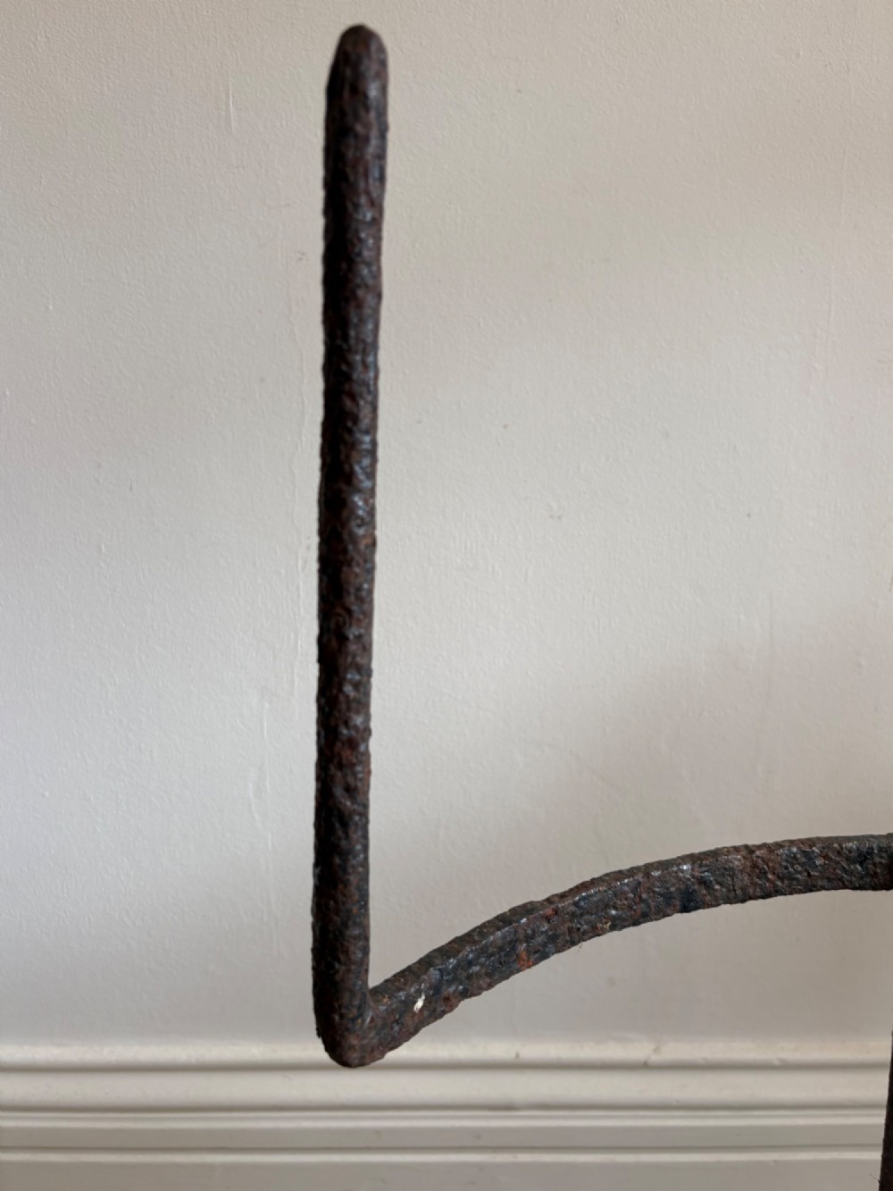 An 18th-century cylindrical carved stone weight featuring an upright hand-forged iron handle attachment. View V