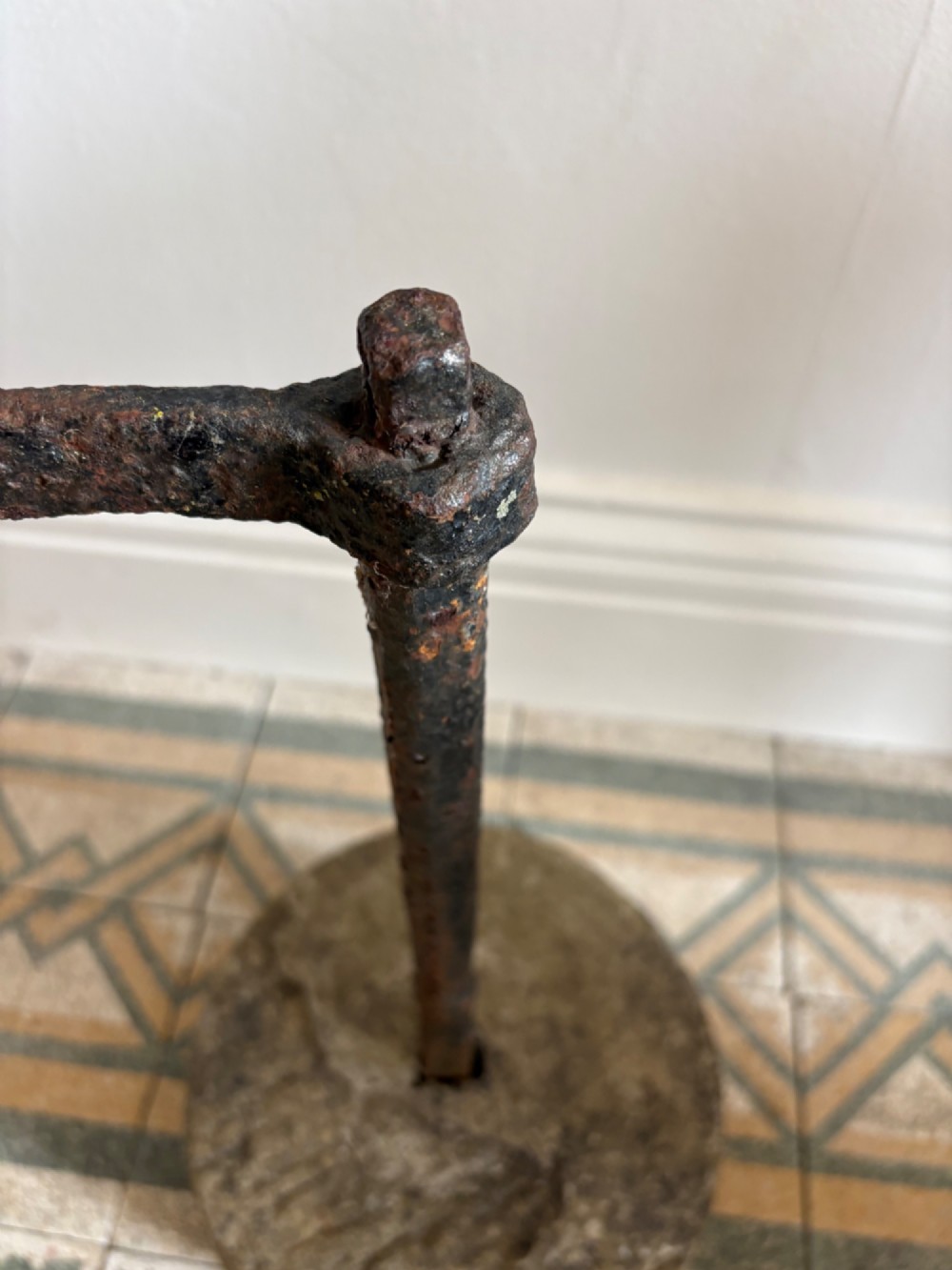 An 18th-century cylindrical carved stone weight featuring an upright hand-forged iron handle attachment. View VI