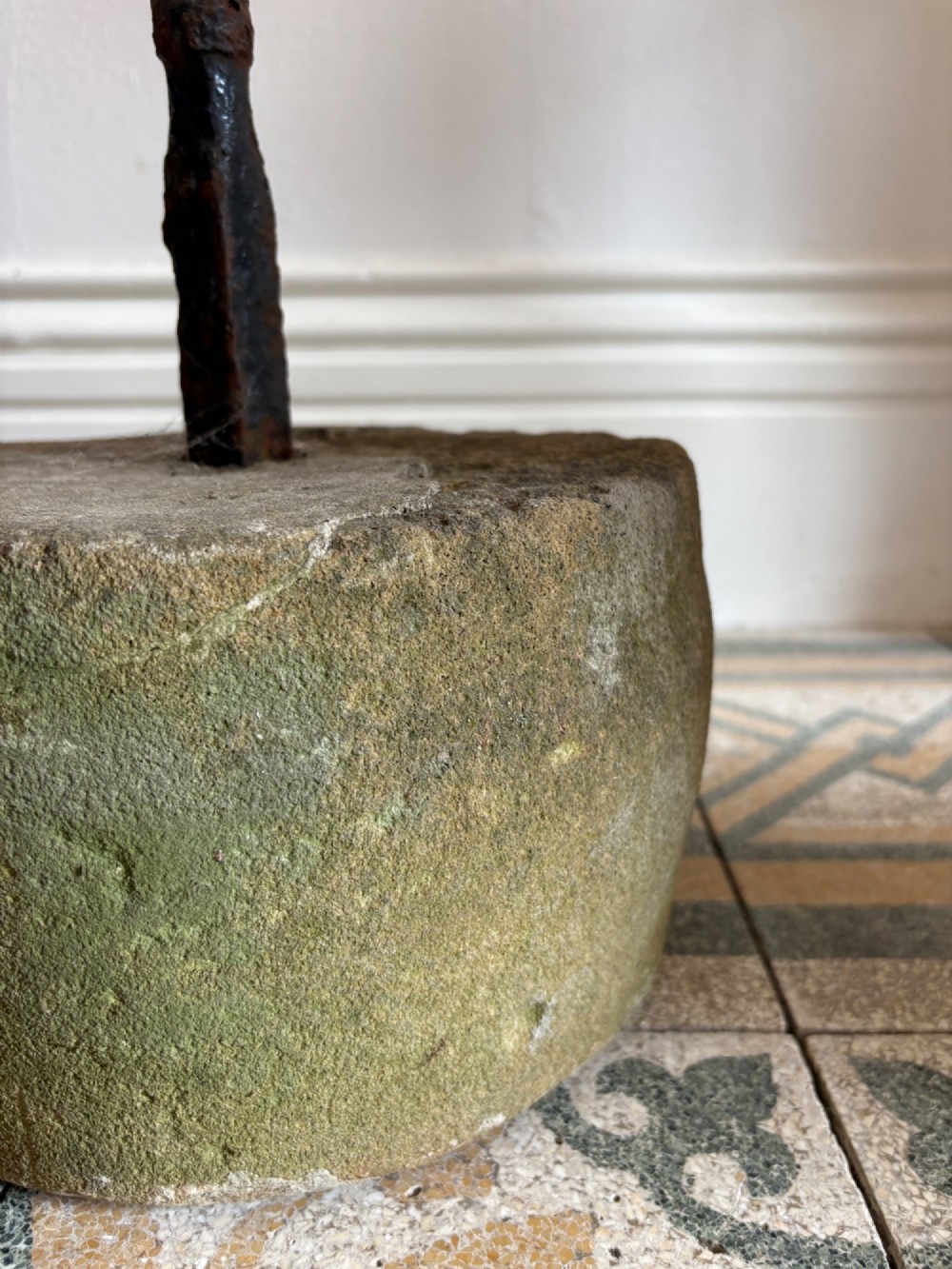 An 18th-century cylindrical carved stone weight featuring an upright hand-forged iron handle attachment. View VIII