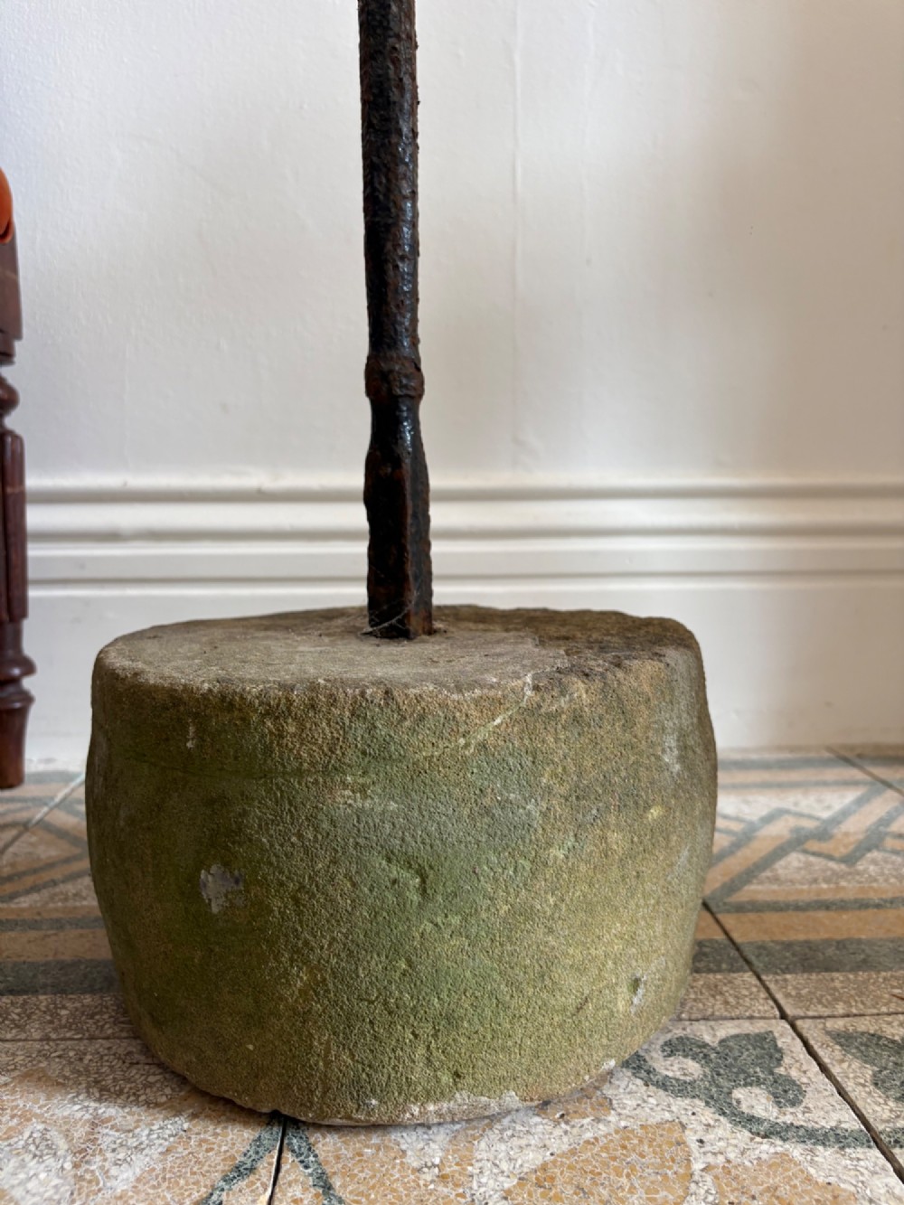 An 18th-century cylindrical carved stone weight featuring an upright hand-forged iron handle attachment. View IX
