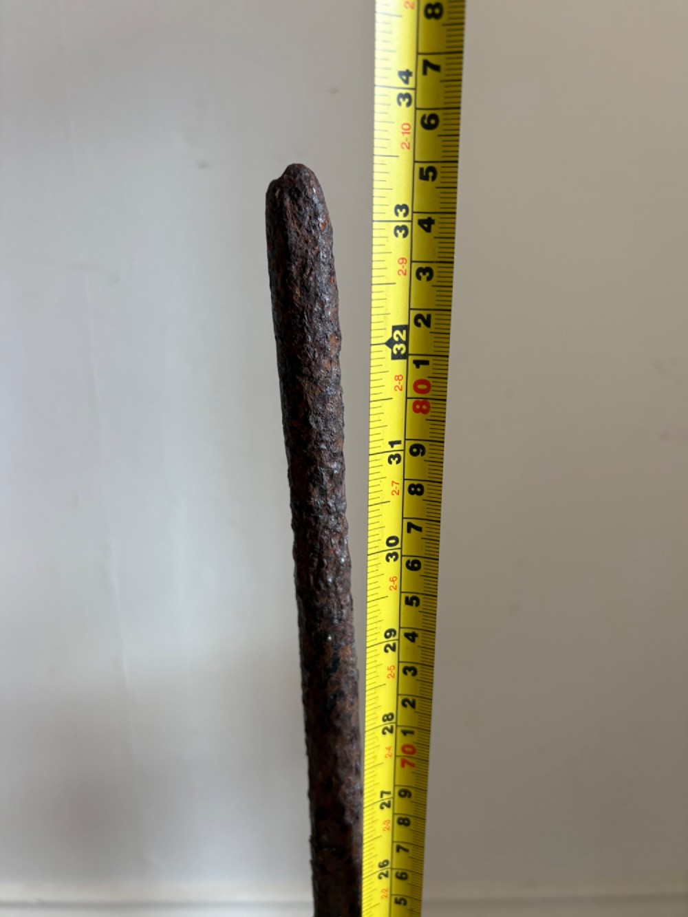 An 18th-century cylindrical carved stone weight featuring an upright hand-forged iron handle attachment. View X