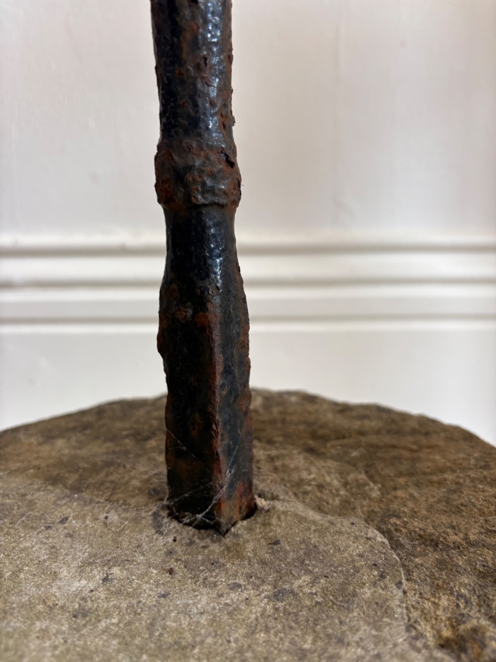 An 18th-century cylindrical carved stone weight featuring an upright hand-forged iron handle attachment. View XIV