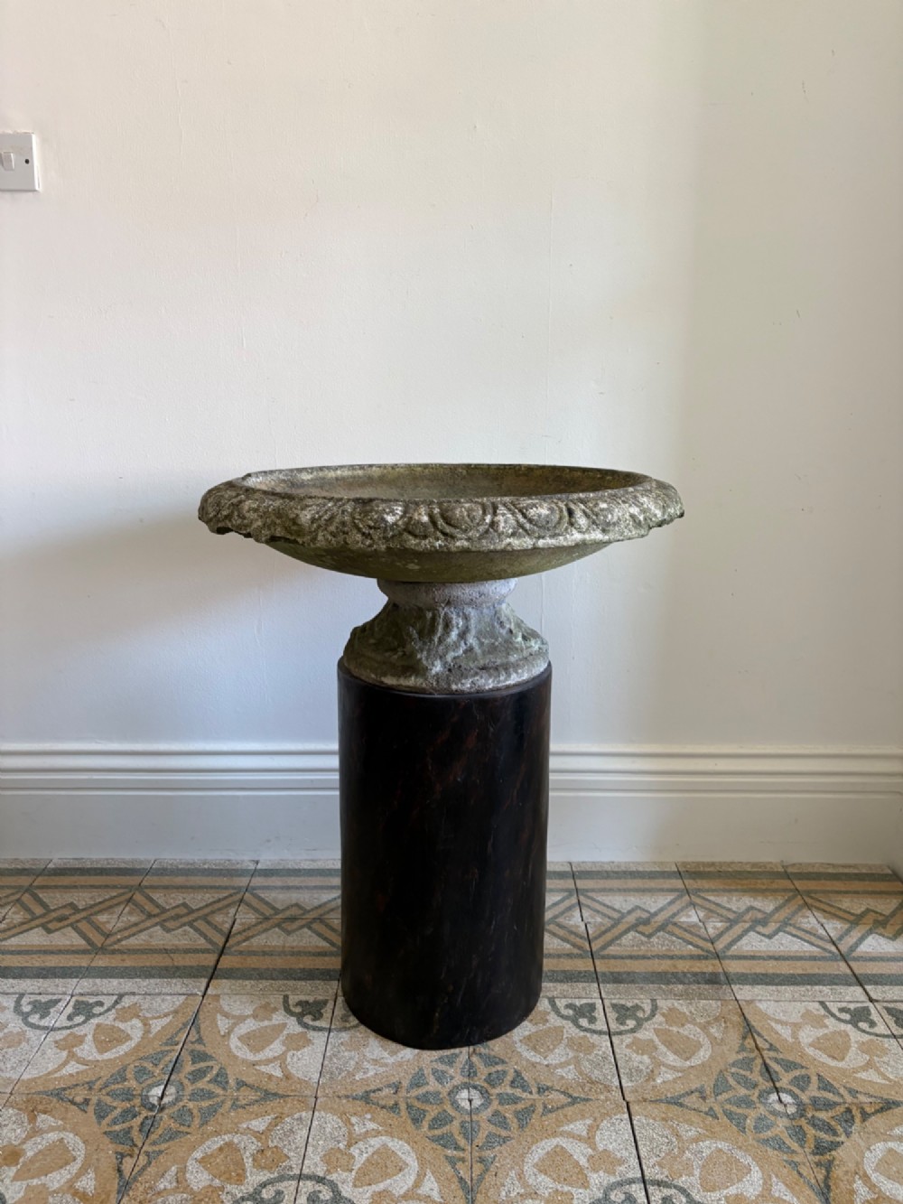 A shallow Neoclassical cast stone birdbath planter with a low moulded pedestal base, displaying a weathered grey and green patinated surface. View II