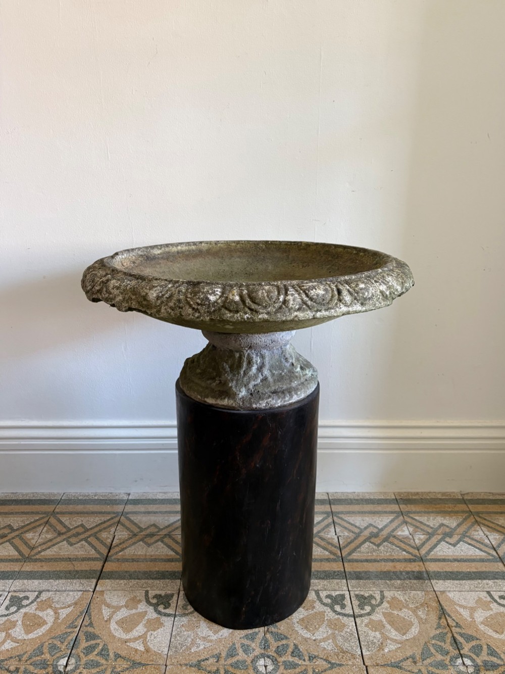 A shallow Neoclassical cast stone birdbath planter with a low moulded pedestal base, displaying a weathered grey and green patinated surface. View IV