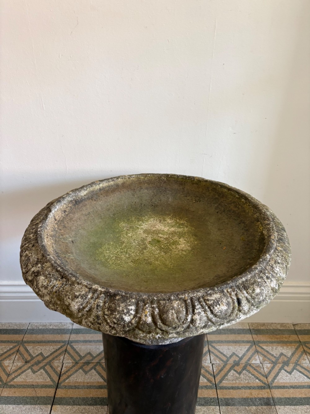 A shallow Neoclassical cast stone birdbath planter with a low moulded pedestal base, displaying a weathered grey and green patinated surface. View V