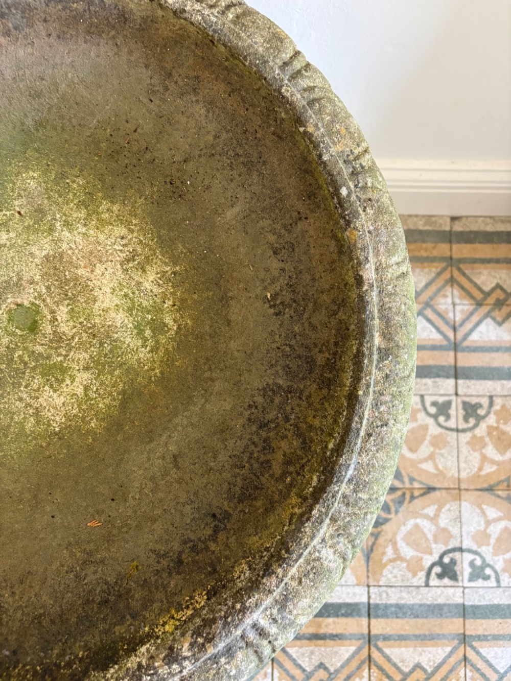 A shallow Neoclassical cast stone birdbath planter with a low moulded pedestal base, displaying a weathered grey and green patinated surface. View IX