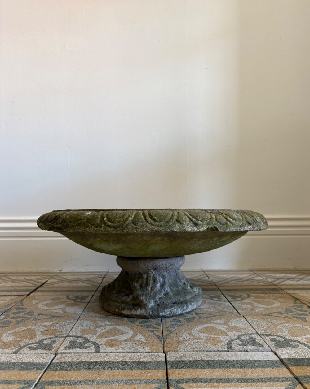 A shallow Neoclassical cast stone birdbath planter with a low moulded pedestal base, displaying a weathered grey and green patinated surface. View X