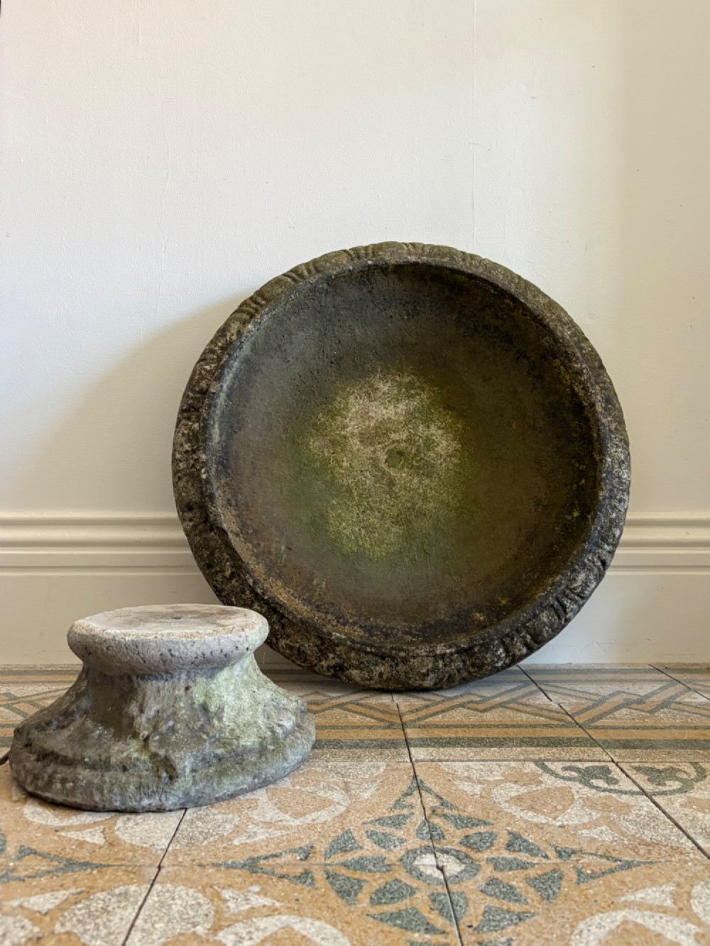 A shallow Neoclassical cast stone birdbath planter with a low moulded pedestal base, displaying a weathered grey and green patinated surface. View XII
