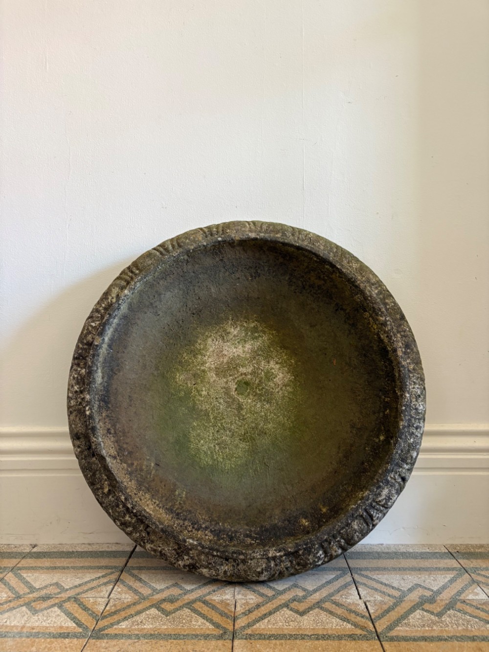 A shallow Neoclassical cast stone birdbath planter with a low moulded pedestal base, displaying a weathered grey and green patinated surface. View XV