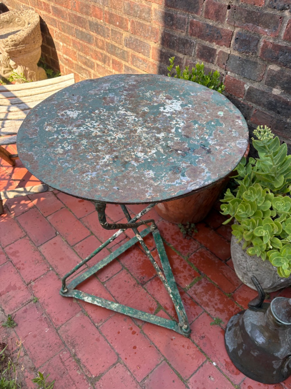 A 19th-century French cast iron gueridon round table featuring distressed green paint and a triangular tripod base.