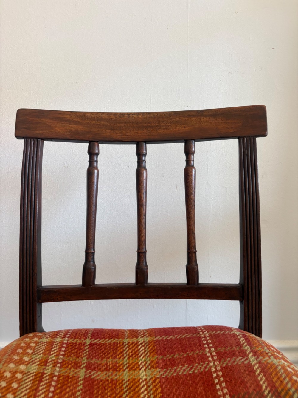 A Regency mahogany and beech side chair featuring a red plaid upholstered seat above an integrated wooden drawer with a brass drop handle. View X