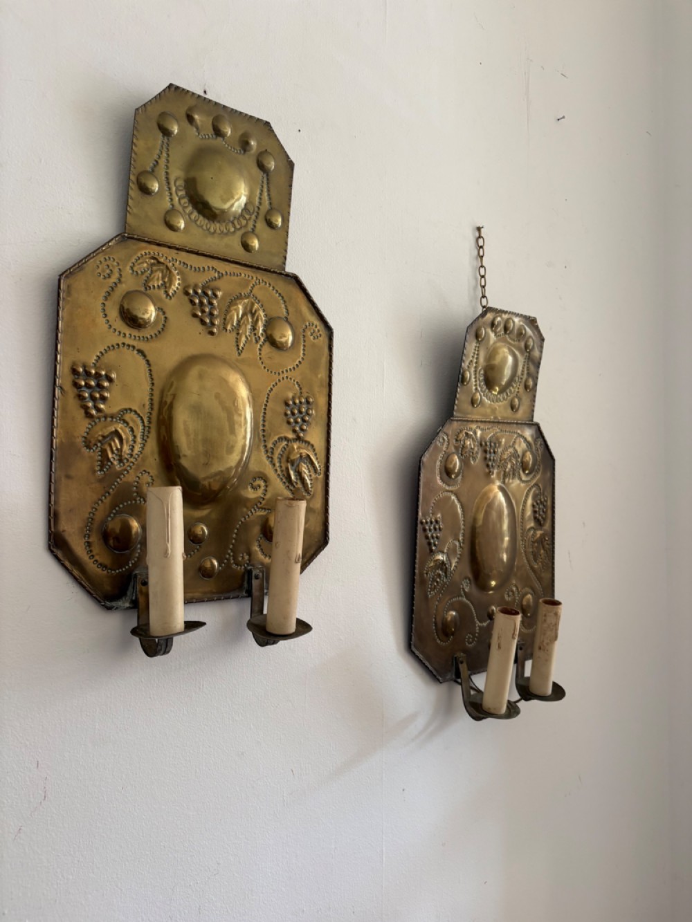 Pair of late 19th-century Dutch repousse brass two-branch wall sconces decorated with embossed grape vine motifs and oval central bosses. View II