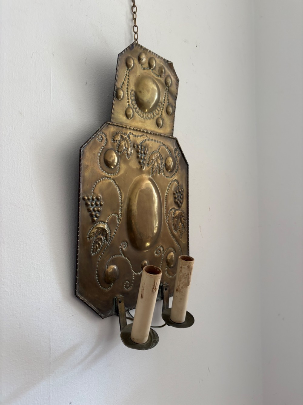 Pair of late 19th-century Dutch repousse brass two-branch wall sconces decorated with embossed grape vine motifs and oval central bosses. View IV