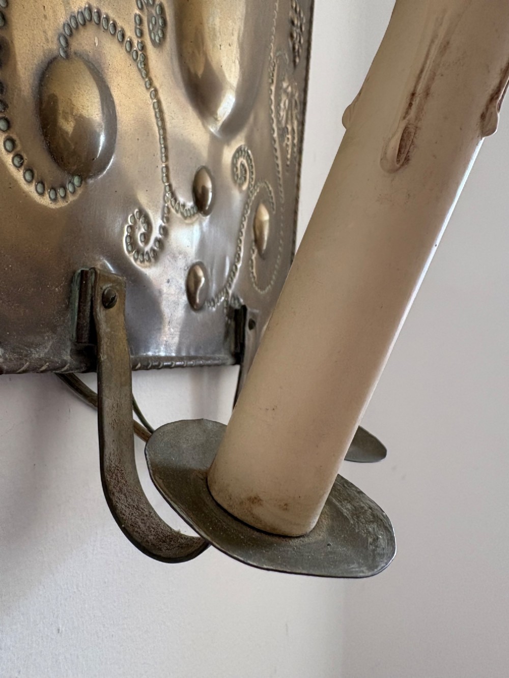 Pair of late 19th-century Dutch repousse brass two-branch wall sconces decorated with embossed grape vine motifs and oval central bosses. View V