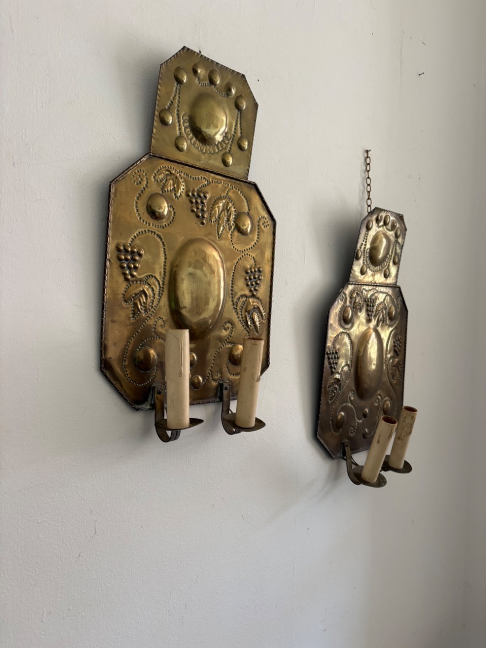 Pair of late 19th-century Dutch repousse brass two-branch wall sconces decorated with embossed grape vine motifs and oval central bosses. View VII