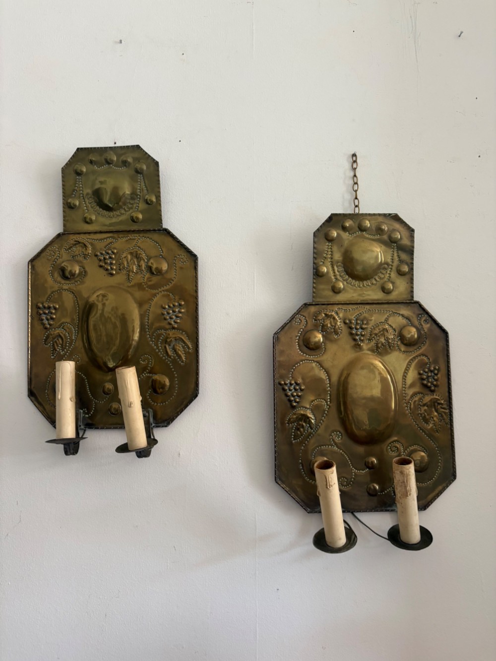Pair of late 19th-century Dutch repousse brass two-branch wall sconces decorated with embossed grape vine motifs and oval central bosses. View VIII