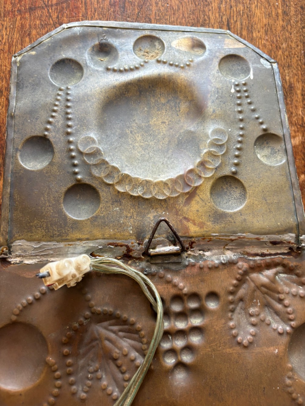 Pair of late 19th-century Dutch repousse brass two-branch wall sconces decorated with embossed grape vine motifs and oval central bosses. View X