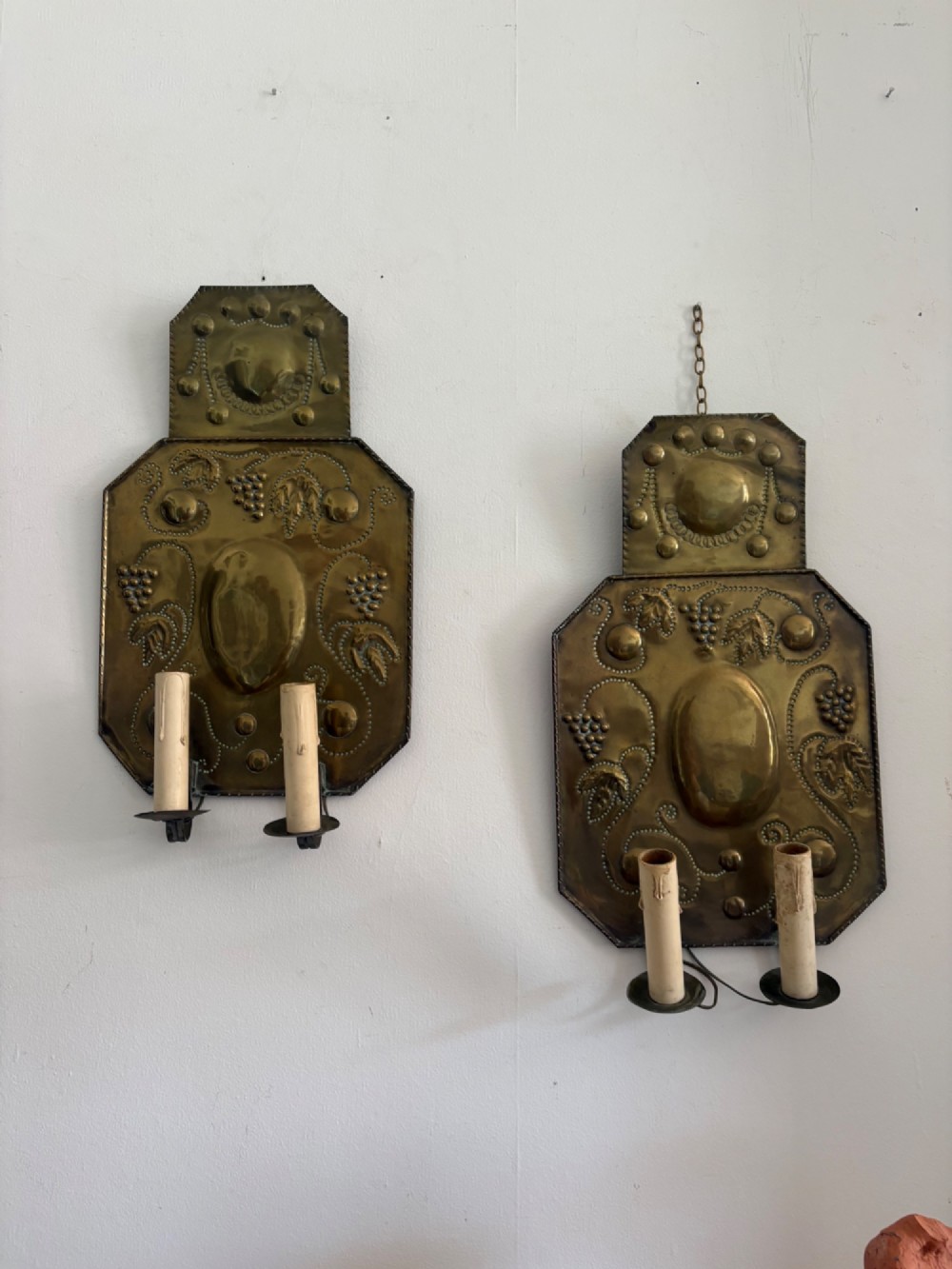 Pair of late 19th-century Dutch repousse brass two-branch wall sconces decorated with embossed grape vine motifs and oval central bosses. View XI
