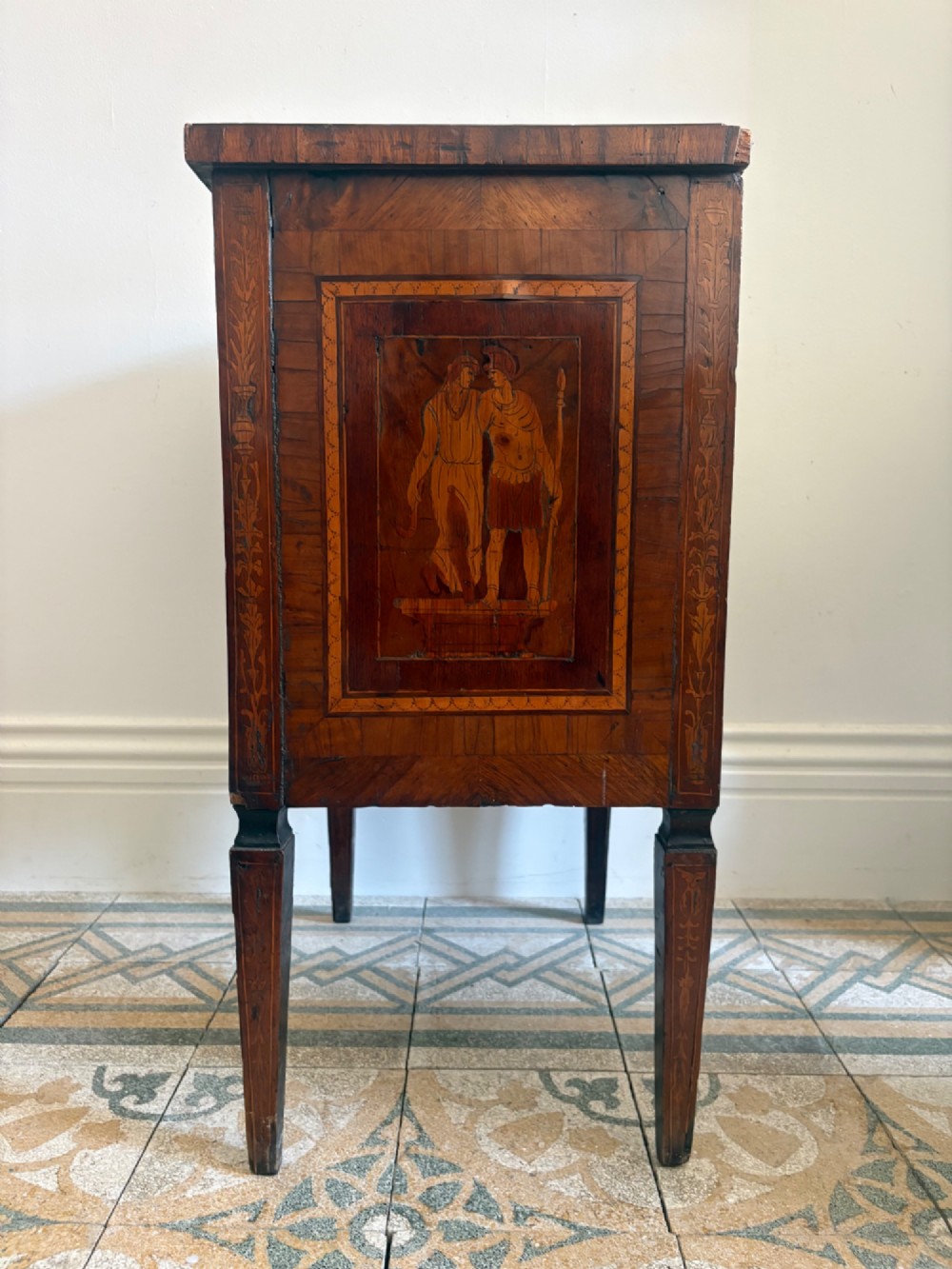 An 18th-century Italian Neoclassical walnut bedside cabinet featuring a central circular figurative marquetry panel on the front door, supported by square tapered legs. View III