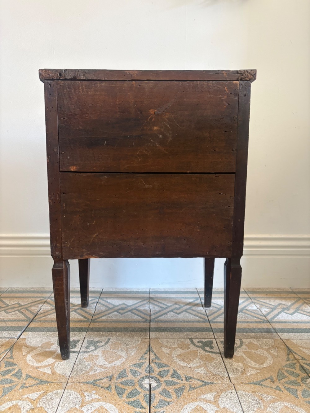 An 18th-century Italian Neoclassical walnut bedside cabinet featuring a central circular figurative marquetry panel on the front door, supported by square tapered legs. View IV