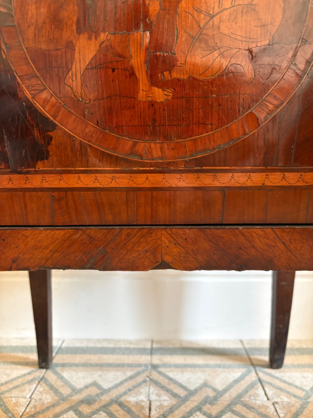 An 18th-century Italian Neoclassical walnut bedside cabinet featuring a central circular figurative marquetry panel on the front door, supported by square tapered legs. View VIII