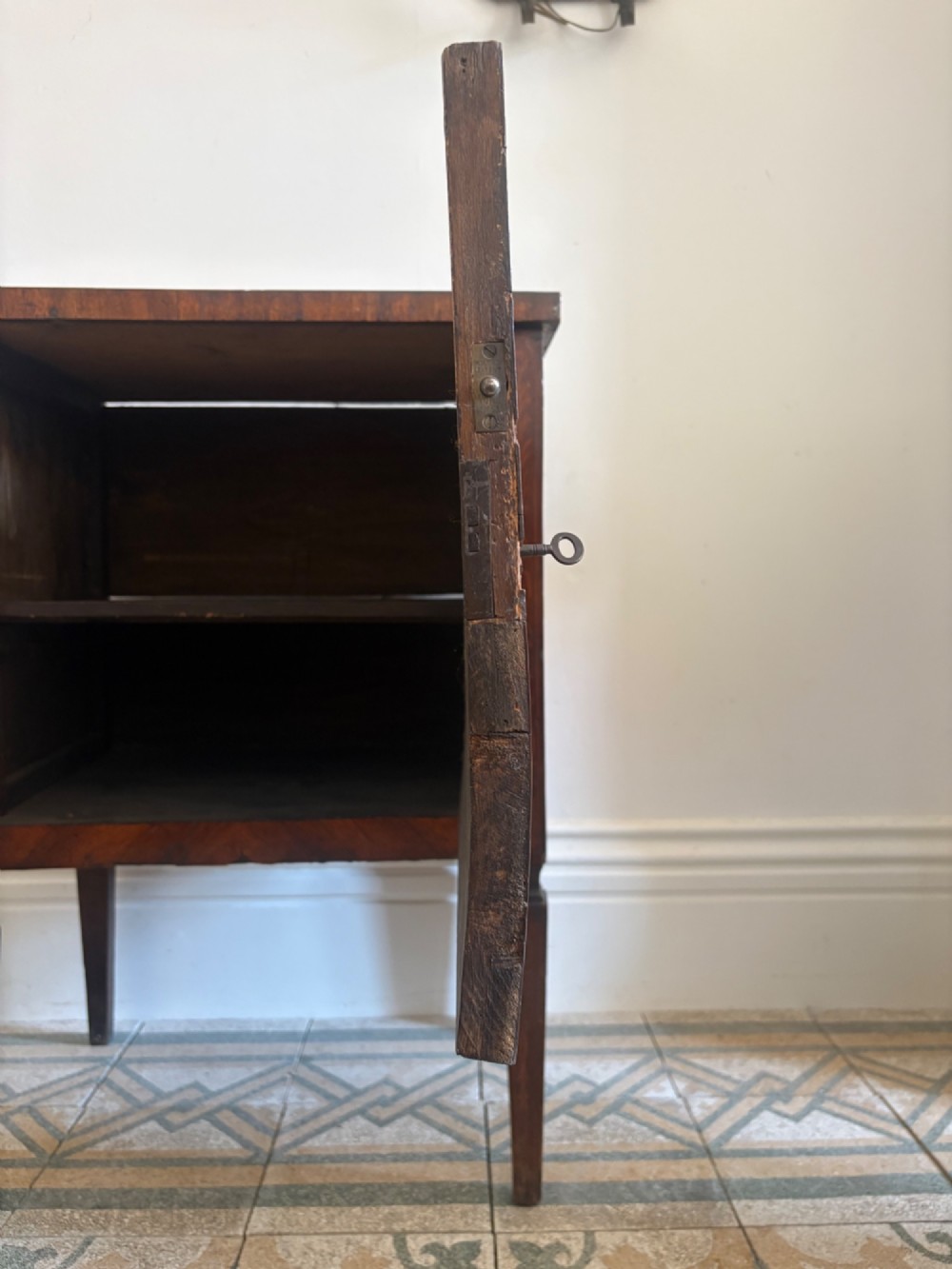 An 18th-century Italian Neoclassical walnut bedside cabinet featuring a central circular figurative marquetry panel on the front door, supported by square tapered legs. View IX