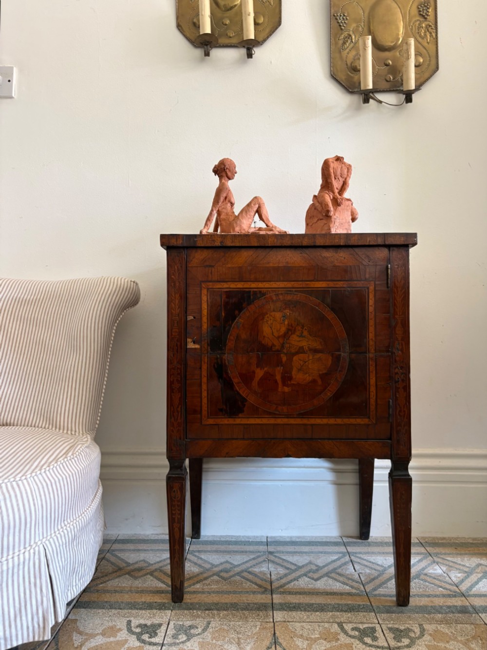An 18th-century Italian Neoclassical walnut bedside cabinet featuring a central circular figurative marquetry panel on the front door, supported by square tapered legs. View XIV
