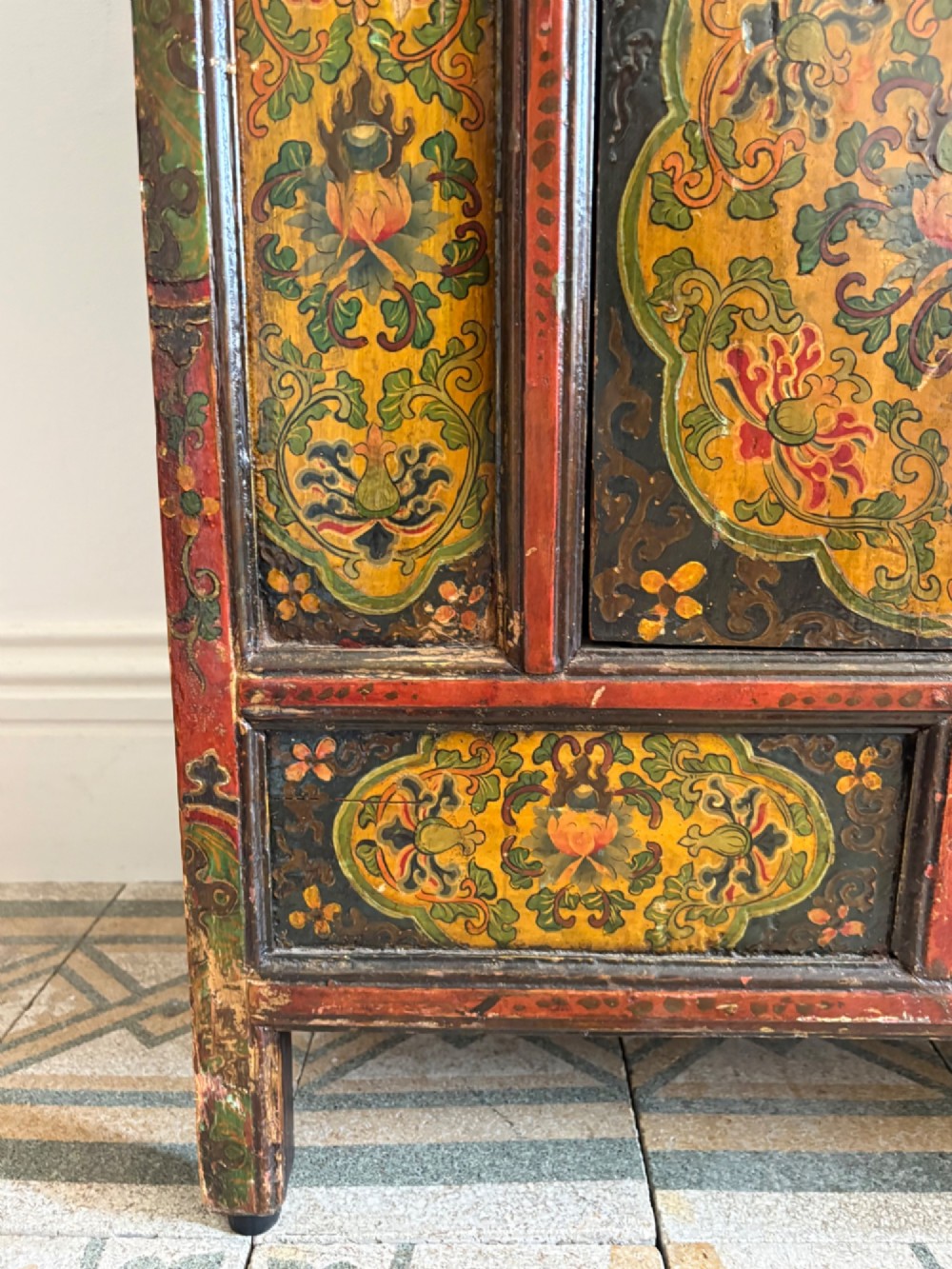 A 19th-century Tibetan wooden cabinet featuring four central hand-painted floral panels framed in red and gold mineral pigments. View XIII
