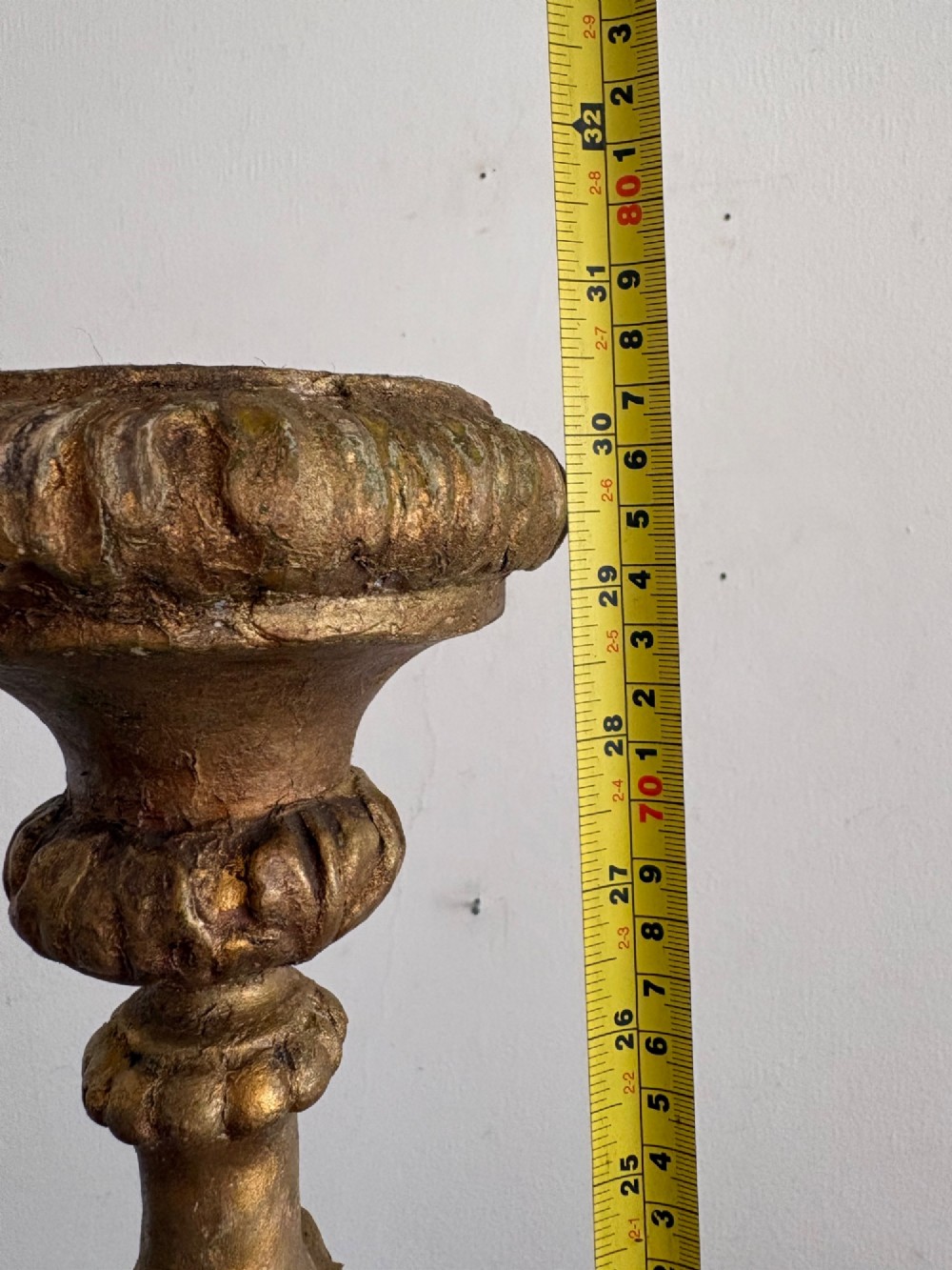 A pair of 18th-century Italian Baroque carved giltwood altar candlesticks featuring triform bases with scrollwork and tall baluster stems. View XII